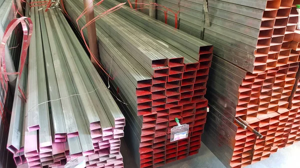 square metal pipe Carbon Steel Pipe Section Stainless steel bars are stacked on top of each other in a metal product warehouse.