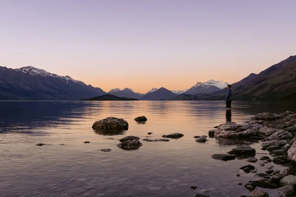 Young man admiring the beuaty in Lake Wakatipu sunset. New Zealand, South Island landscape