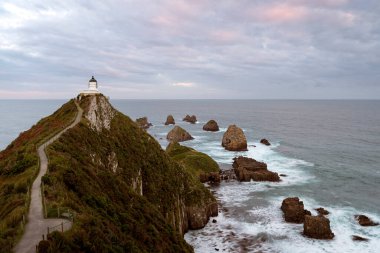 Pasifik Okyanusu 'ndaki kayalıkların üzerindeki Nugget Point ve deniz feneri. Yeni Zelanda, Güney Adası.