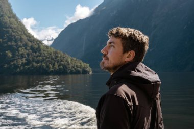 Beyaz adam Milford Sound Cruise 'da eğleniyor. Fiordland Ulusal Parkı, Yeni Zelanda.