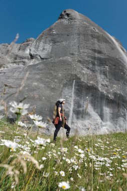 Castle Hill 'deki büyük kayaya hayran genç bir kadın. Narnia Filmi Yeni Zelanda 'da geçiyor. Dikey fotoğrafçılık