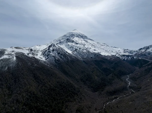 Karla kaplı Lanin Volkanı ve Sarmal Nehirli Dağ Vadisi 'nin havadan görünüşü. Lanin Ulusal Parkı, Arjantin