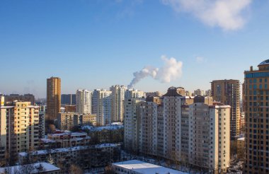 Reutov, Moskova bölgesi, Rusya-Ocak 17, 2021: Açık mavi bir gökyüzü ve kopyalamak için açık mavi alana karşı soğuk kış günlerinde modern yüksek konut binaları ile şehrin panoramik manzarası