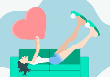 Beyaz bluzlu, mavi şortlu ve terlikli, sevimli, mutlu bir kız kanepeye uzanmış gri arka planda ve fotokopi odasında büyük pembe bir kalp tutuyor. Sevgililer Günü konsepti