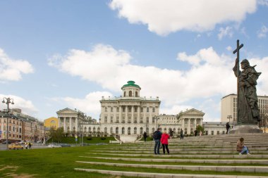 Peshkov Evi 'nin beyaz tarihi sarayının panoramik görüntüsü ve bir bahar günü bulutlu bir gökyüzünün arka planında geçen arabalar. Moskova Rusya 'da ünlü bir yer.