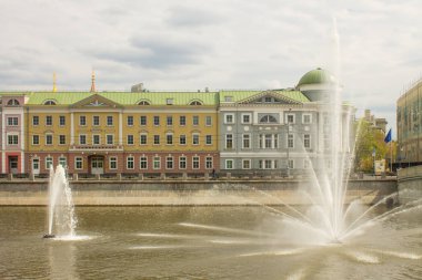 Moskova, Rusya-Mayıs, 5, 2021: Güneşli bir bahar gününde Avrupa Birliği Misyonu ve su kaynaklarının tarihi binası olan Vodootvodnoy Kanalı 'ndaki Kadashevskaya Embankment manzarası
