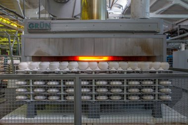 Moskova bölgesindeki bir porselen fabrikasına yakın çekim yapmak için egzoz fırınına yerleştirilmiş kapaklı beyaz seramik tencereler.