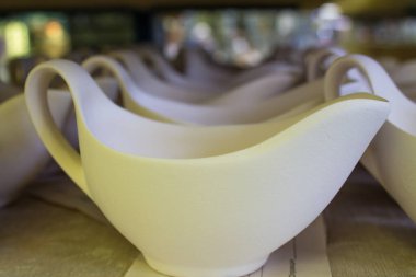 Rusya 'nın Moskova bölgesindeki bir porselen fabrikasının metal raflarında sıra sıra duran beyaz seramik tabaklar.