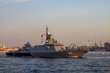 Bir savaş gemisi şafak vakti Saint-Petersburg Rusya 'da setin ve tarihsel mimarinin arka planına karşı Neva Nehri boyunca yol alıyor.