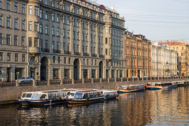 Saint PETERSBURG, RUSSIA-July, 15, 2021: Moika Nehri kıyısı ve demirlemiş tekneler ile birlikte su ve tarihi binalar yaz sabahı erken saatlerde