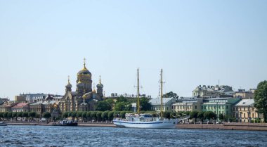 Aziz PETERSBURG, RUSSIA-HAZİRAN, 16, 2021: Güneşli bir yaz günü ve uzayda güneşli bir yaz günü Neva Nehri yakınlarındaki Teğmen Schmidt setinde Meryem Ana 'nın Varsayımının Güzel Kilisesi