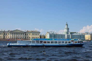 Saint Petersburg, Rusya-Temmuz, 17, 2021 Müze-Kunstkamera 'nın Neva Nehri seti üzerindeki tarihi binasını ve bir turist teknesini ve güneşi kopyalamak için bir alan