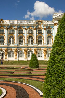 St. Petersburg, Rusya, 21 Temmuz 2021: Tsarskoye Selo 'da güneşli bir yaz gününde mavi bulutlu bir gökyüzüne karşı geometrik çiçek tarhlarıyla Catherine Sarayı cephesi