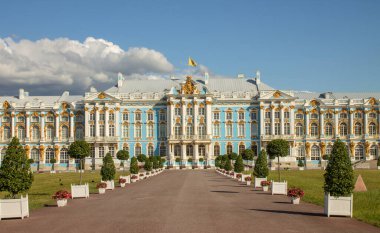 PUSHKIN, Leningrad REGION, RUSSIA-JULY, 21, 2021: Güneşli bir yaz gününde Tsarskoye Selo 'da güzel bitki yatakları ve ağaçları olan muhteşem mavi ve beyaz Catherine Sarayı