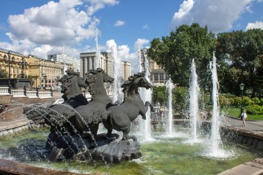 MOSCOW, RUSSIA-AUGust, 4, 2021: Manezhnaya Meydanı 'ndaki ünlü çeşme - güneşli bir yaz gününde üç at ve su fışkırtan jetler
