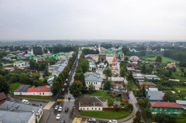 Ağaçların yeşil yaprakları arasında tarihi mimarisi olan eski şehrin panoramik manzarası ve Suzdal Rusya 'da bulutlu bir yaz günü.