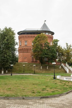 SUZDAL, VLADIMIR REGION, RUSSIA-AĞust, 11, 2021: Müze tuğlası su kulesi ve bulutlu bir yaz gününde yeşil ağaçlar