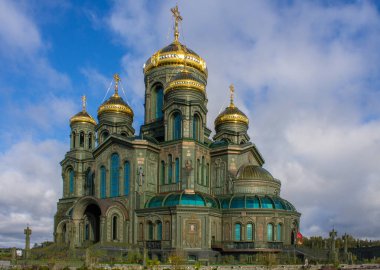 KUBINKA, MOSCOW REGION, RUSSIA-AUGust, 22, 2021: Rus Silahlı Kuvvetleri 'nin modern ana tapınağının ön cephesi Vatanseverlik Parkı' nda mavi bulutlu bir gökyüzüne karşı altın kubbeler.