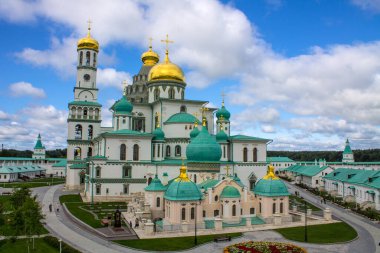 Güneşli bir yaz gününde, Yeni Kudüs 'te altın kubbeli beyaz taş kiliselerden oluşan güzel bir mimari yapı bulutlu açık mavi gökyüzüne karşı.