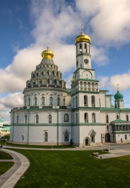 Güneşli bir günde Yeni Kudüs 'ün beyaz taşlı dini mimarisi ve Istra Rusya' da bulutlarla dolu dramatik mavi bir gökyüzü ile mimari bir arada.