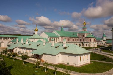 Güneşli bir günde Yeni Kudüs 'ün beyaz taşlı dini mimarisi ve Istra Rusya' da bulutlarla dolu dramatik mavi bir gökyüzü ile mimari bir arada.