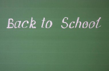 El yazısı yazması: okula geri dön ve tebeşir çizgileri olan yeşil bir karatahtaya yer kopyala