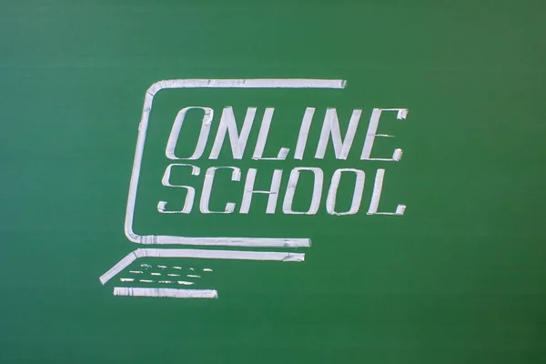 The inscription is an online school in English written in white chalk on a green blackboard and a space for copying. Concept-remote education