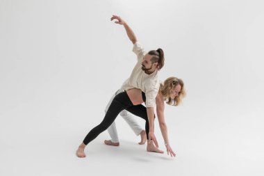 Stüdyoda temas yogası yapan birkaç genç insan. Psikolojik terapi sırasında erkek ve kadın birbirlerine yaslanırlar.