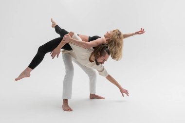 Stüdyoda temas yogası yapan birkaç genç insan. Psikolojik terapi sırasında erkek ve kadın birbirlerine yaslanırlar.