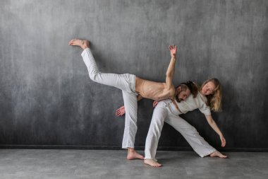 Stüdyoda temas yogası yapan birkaç genç insan. Psikolojik terapi sırasında erkek ve kadın birbirlerine yaslanırlar.