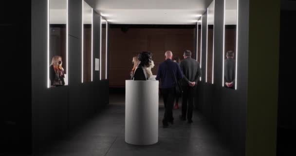 Посетители музея в масках для лица на выставке статуй — стоковое видео