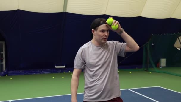 Betaald moe na spel en stuiteren een tennisbal met zijn racket — Stockvideo