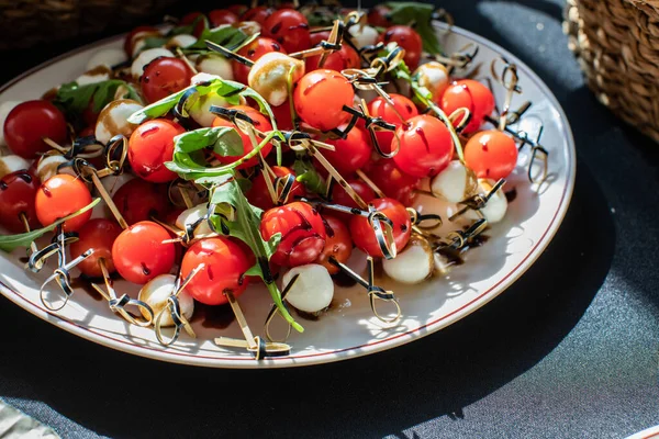 Küçük domatesli kanepeler, mozarella peyniri ve roka.