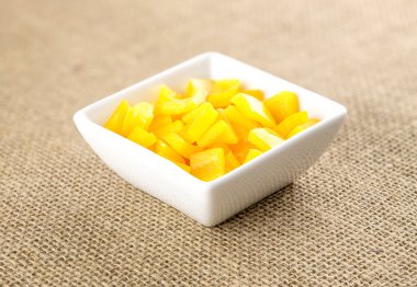 Kendir backgrou karşı kare kapsayıcısında doğranmış sarı biber