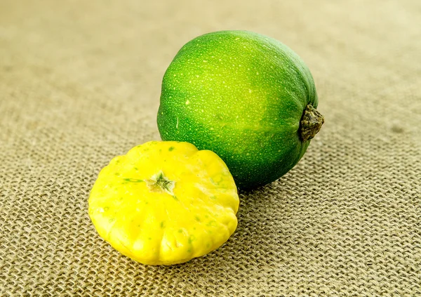 Ярко-желтая пуговица для сквоша и зеленая жемчужина — стоковое фото
