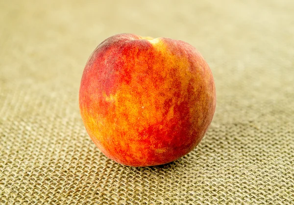 Organic naturally harvested peach on hessian background