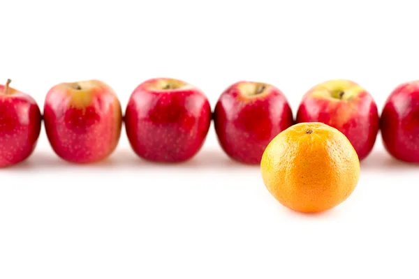 Single orange infront of line of apples — Stock Photo, Image