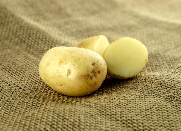 Ganze Kartoffeln und geschnittene Kartoffeln auf Klette — Stockfoto