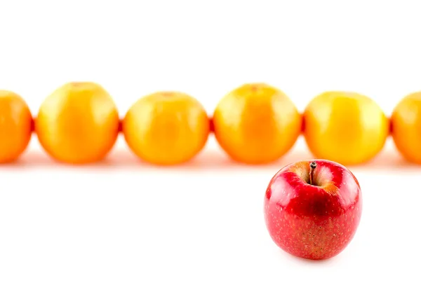 Червоне яблуко на передньому плані апельсинів, непарне — стокове фото