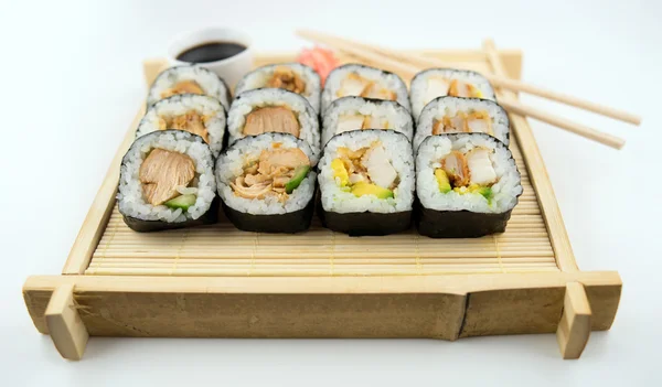 Teriyaki and fried chicken sushi rolls on Japanese bamboo mat wi — Stock Photo, Image