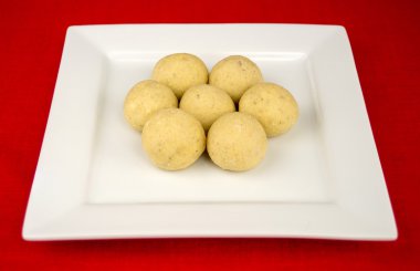 Beyaz bir kare plaka üzerinde yuvarlak Hint laddu tatlılar