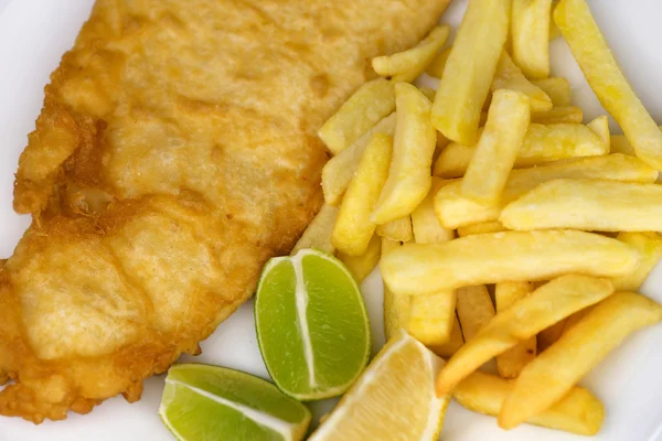 Batatas fritas salgadas com grande porção de peixe frito com limão — Fotografia de Stock