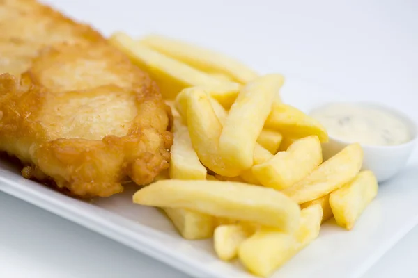 Primo piano di pesce e patatine fritte con salsa tartara su bianco — Foto Stock