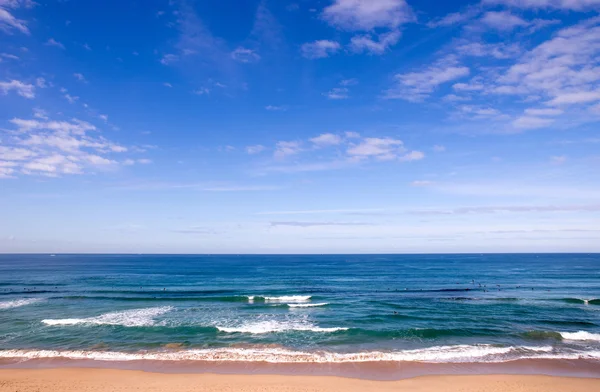 Strand met blauwe hemel en golven — Stockfoto