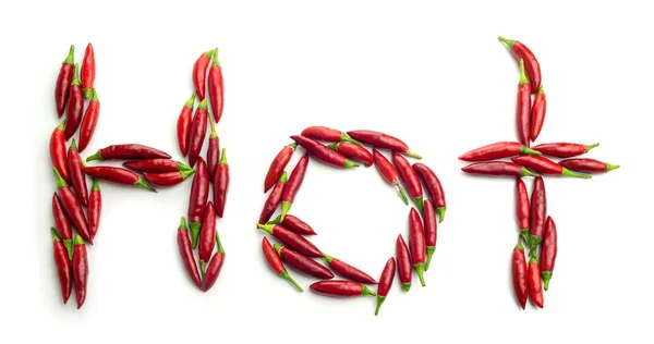 Pimentas vermelhas maduras em forma de pimenta na palavra Quente — Fotografia de Stock