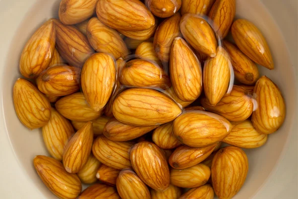 Closeup of almonds soaked in water — Stock Photo, Image