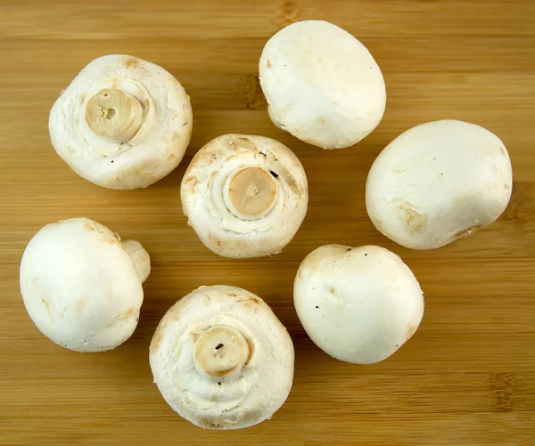 Common mushrooms on cutting board — Stock Photo, Image