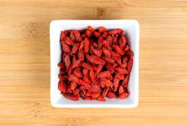 Makro kurutulmuş kırmızı goji çilek woode karşı beyaz kase