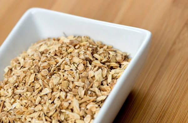 Macro of astragalus root chips against a wooden board — Stock Photo, Image