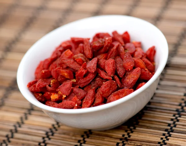 Dehydrierte Goji-Beeren in Schüssel auf orientalischer Matte — Stockfoto